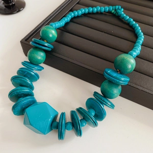 Detail of turquoise wooden necklace with large faceted beads on jewelry display tray