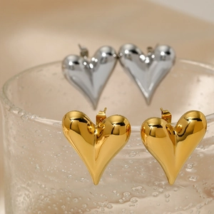 Chic hollow heart earrings in gold and silver finish on a water droplet glass surface