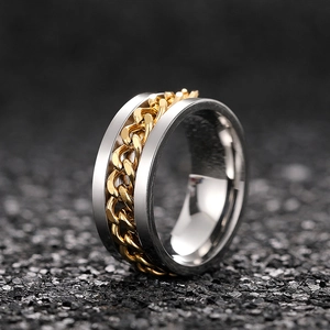 Macro detail of the rotating golden Cuban chain inlay on a wide silver stainless steel ring
