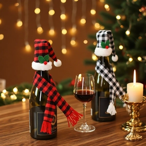 Christmas plaid wine bottle covers with mini hats and scarves on a wooden table