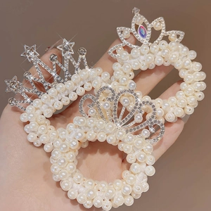 Dettaglio di tre elastici per capelli a corona di perle con strass scintillanti per bimba