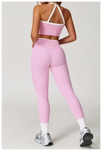 Detail van roze yogaset met kruislings rugontwerp en witte bies op de sport-bh