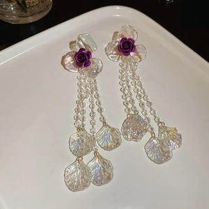 Close-up of purple flower tassel earrings with transparent beads and iridescent petals