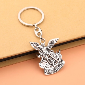 Close-up of Saint Michael silver metal keychain featuring angel relief on card background