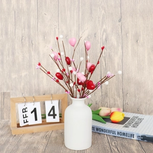 Branches de baies en cœur de Saint-Valentin dans un vase blanc sur un décor boisé
