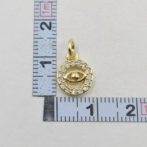 Detailed view of gold plated evil eye pendant with size measurements on white background