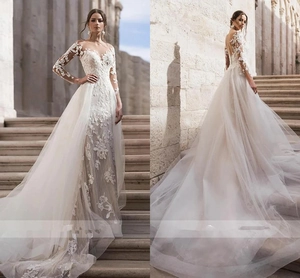 Detail of white long sleeve lace wedding dress with sheer embroidery and long train