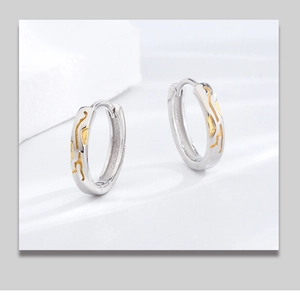 Macro detail of S925 sterling silver hoop earrings with vintage gold textured finish