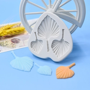 Stampo in silicone per foglie di palma con campioni di foglie in pasta di zucchero blu e arancio