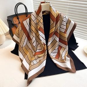 Detailed close-up of large square silk scarf featuring retro braided patterns and rich colors