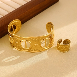 Detail view of gold jewelry set with hammered texture and geometric hollow design