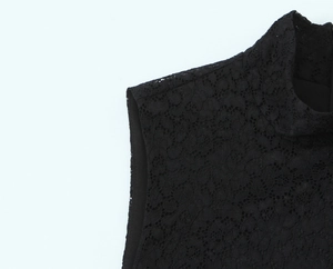 Close-up of intricate black lace stitching on the collar of a high-neck sleeveless dress