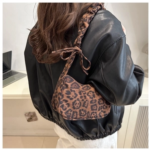 Borsa sottobraccio leopardata con fiocco decorativo sulla tracolla indossata da una modella