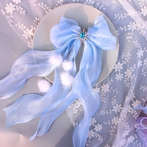 Detail of blue organza bow clip with snowflake crystal and white plush pompoms