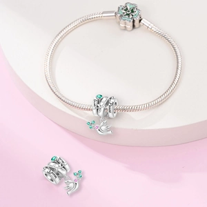 Detailed view of silver charm with Love and Peace engraving and green zircon stones