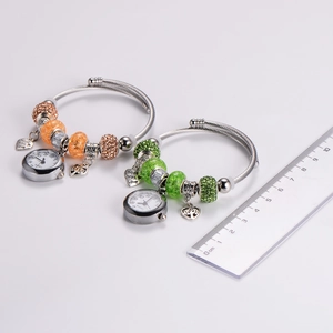 DIY charm bracelet with quartz watch, heart pendant and colorful beads on white background