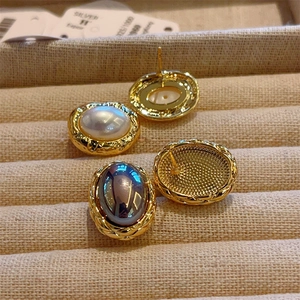 Detailed macro view of retro 18K gold-plated pearl earrings with S925 silver posts