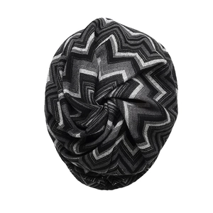 Detailed close-up of thick knitted fabric showing black and white wave pattern texture