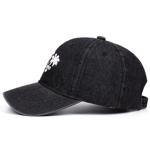 Washed black cotton baseball cap with white palm tree embroidery on a white background