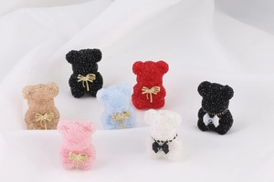 Detailed view of colorful sugar-textured bear charms with bows for DIY jewelry making