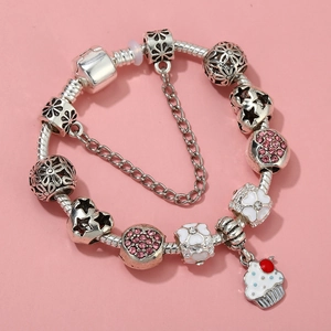 Close-up of silver-plated bracelet with pink rhinestones, enamel flowers and cupcake charms