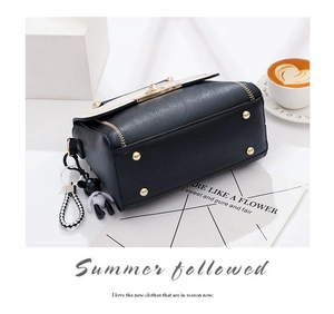 Detail view of contrast crossbody bag with metal feet and cute bear pendant accessory