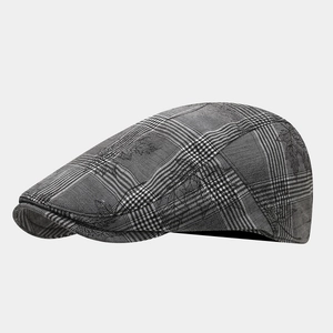 Detail of grey glen plaid texture and stitching on a British style vintage flat cap