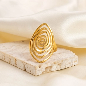 Macro shot of 18K gold plated spiral water drop ring on a textured stone display