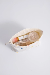 Detail of white floral canvas makeup bag showing spacious interior and embroidered dots