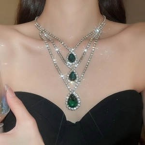 Primo piano della collana elegante con tre gocce d'acqua verdi e strass scintillanti