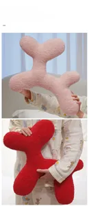Detail of plush dog-shaped pillows in pink and red with soft sherpa texture
