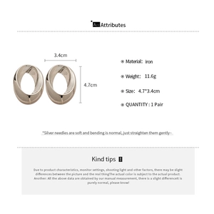 Macro view of polished oval hoop earrings in silver showing product dimensions and texture