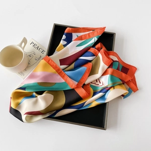 Chic 70x70cm satin square scarf with vibrant geometric patterns in a black tray