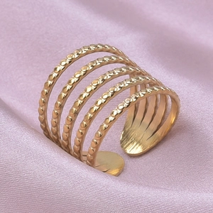 Detail of five-layer gold stainless steel ring with exquisite beaded texture on satin