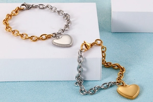 Macro view of heart pendant bracelets featuring two-tone gold and silver link chains
