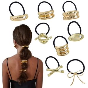 Detail of 8 golden alloy ponytail holders with smooth, hammered and twisted designs