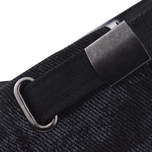 Close-up of black heavy-duty nylon webbing with matte dark grey metal buckle and D-ring