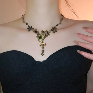 Close-up of vintage gold necklace with multicolored crystals and floral pendant design