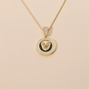 Gros plan du pendentif tête de lion dorée avec yeux verts et pierres de zircone