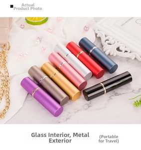 Detail of colorful 10ml portable travel perfume spray bottles on marble background