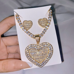 Golden heart-shaped jewelry set with necklace and earrings encrusted with clear crystals
