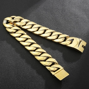 Close-up of golden Cuban link necklace with heavy metal texture and secure clasp