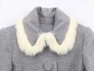 Close-up of grey textured coat with soft white faux fur collar and round button detail