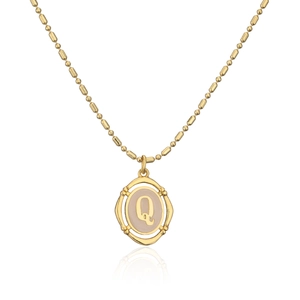 Collar de latón bañado en oro con colgante letra Q e incrustación beige en fondo blanco