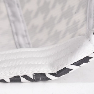 Macro detail of houndstooth baseball cap showing precise multi-row stitching and fabric texture