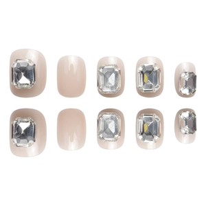 Short nude pink press-on nails set with large rectangular crystals and glossy finish
