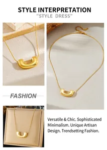 Detailed view of a gold U-shaped pendant necklace with polished finish on a stone surface