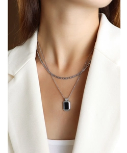 Close-up of double layer silver Cuban chain with a black rectangular pendant on model