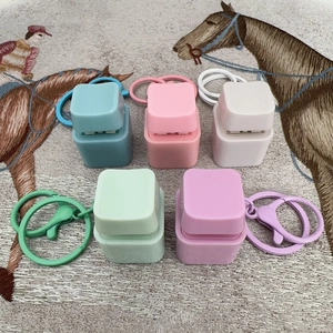 Mechanical switch fidget toy keychains in five pastel colors on a patterned fabric