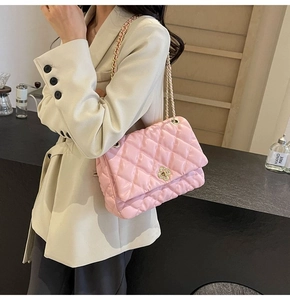 Close-up of pink quilted faux leather bag with gold floral clasp and chain strap